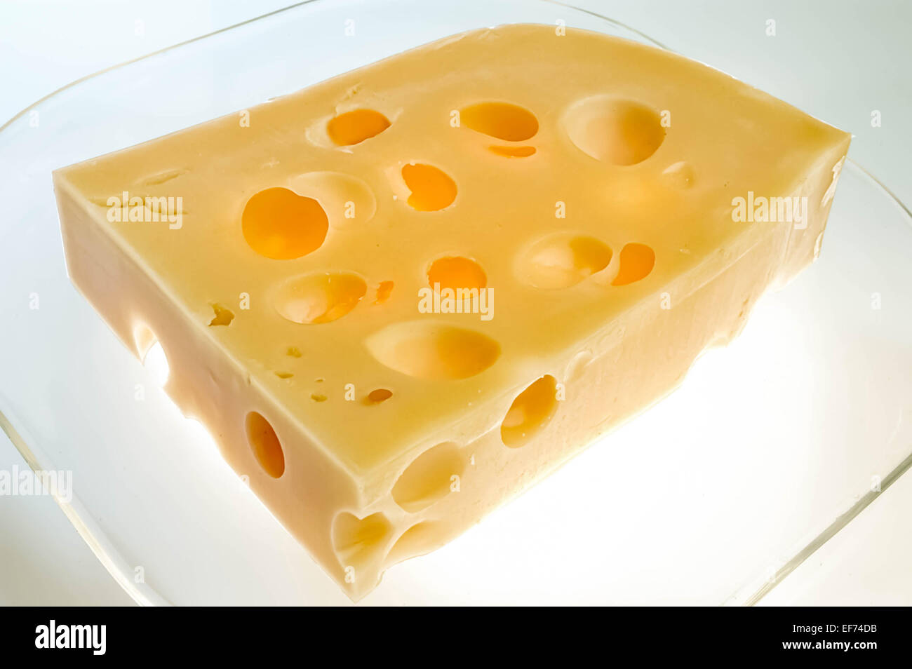 Un pezzo di formaggio con fori Foto Stock