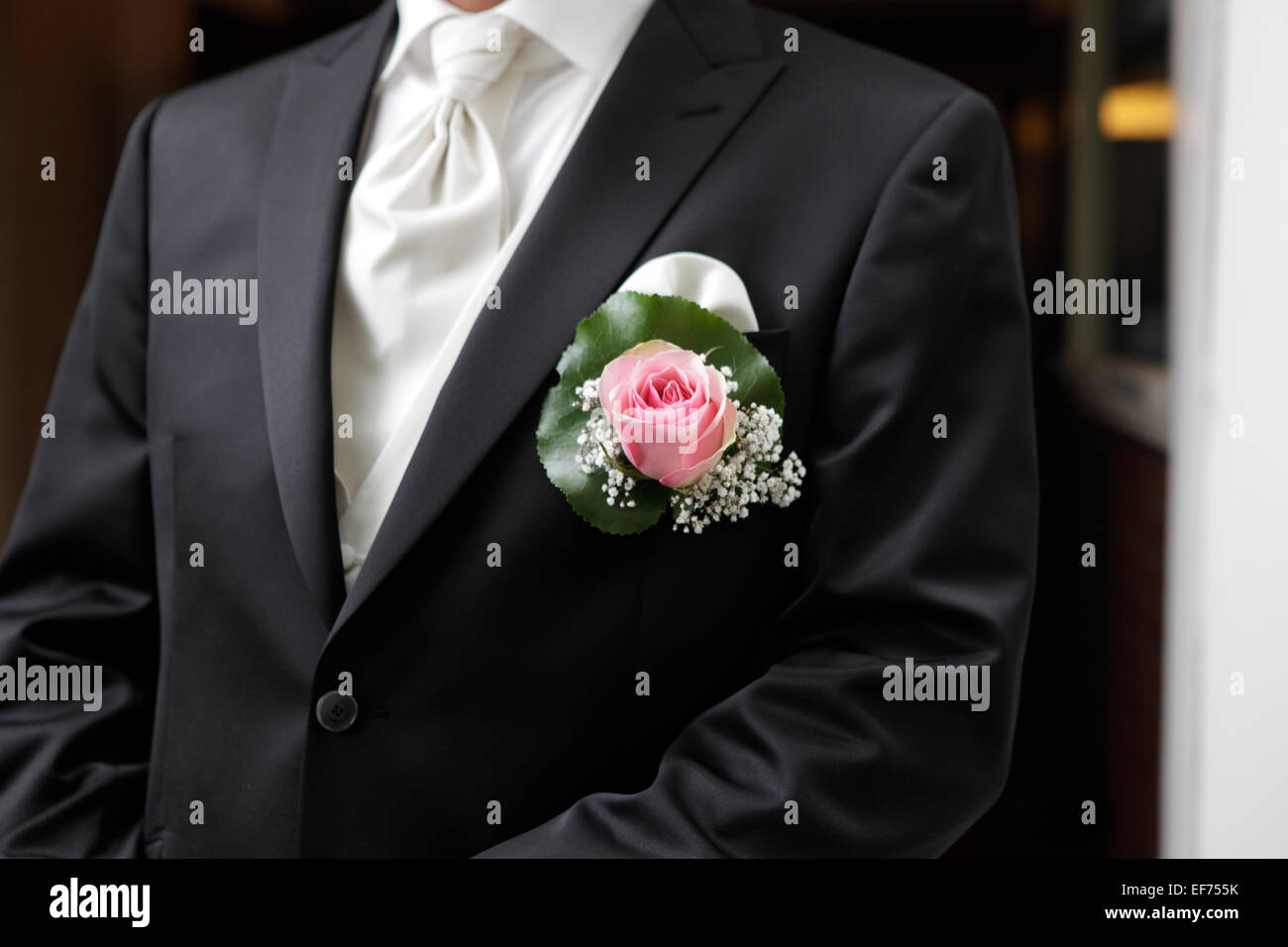 Un uomo nel suo giorno di nozze in un vestito con Rose ostruito Foto Stock