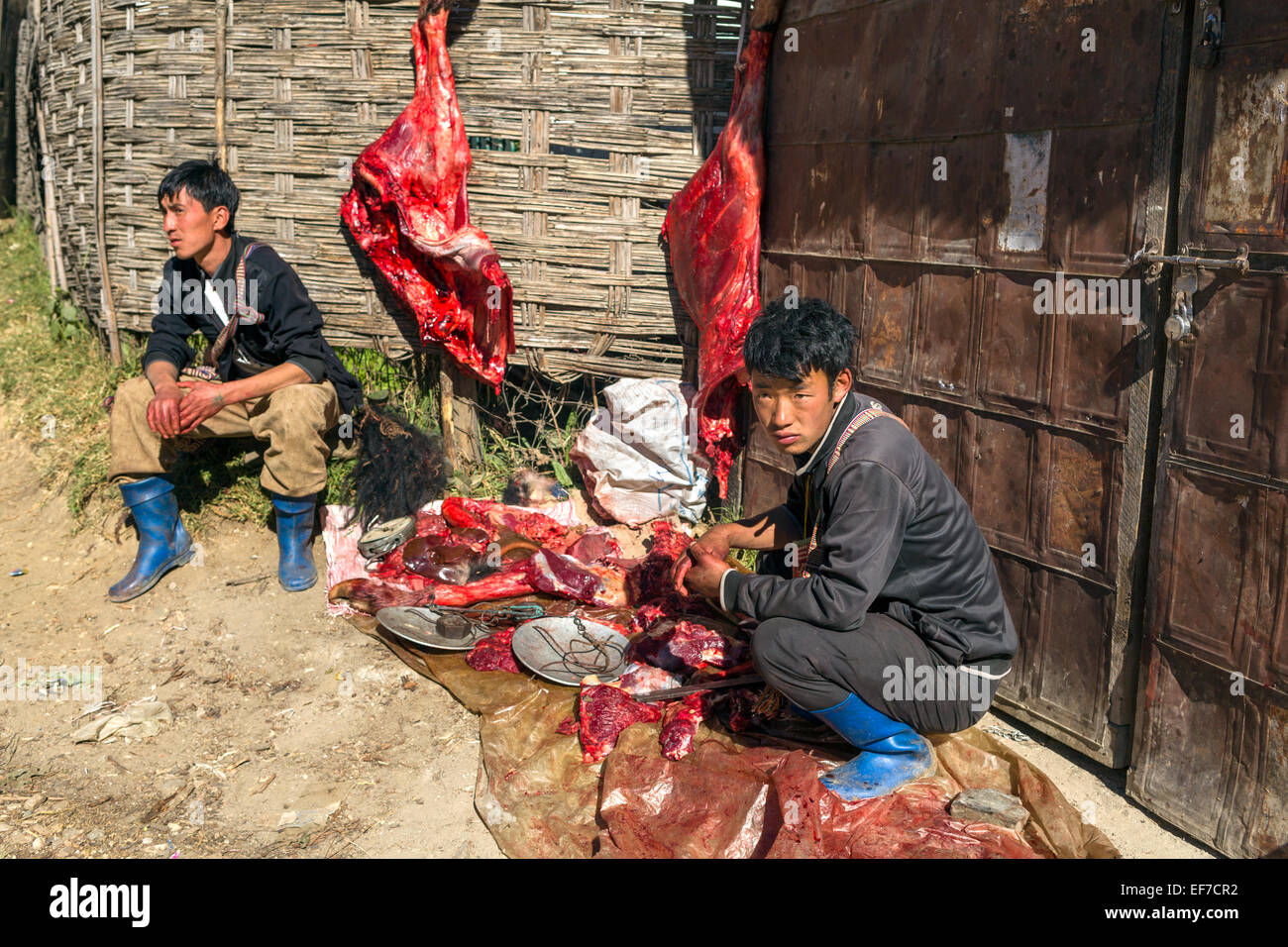 Gli uomini di vendita di carne di yak su un piccolo mercato locale della provincia di West Kameng in Arunachal Pradesh Foto Stock