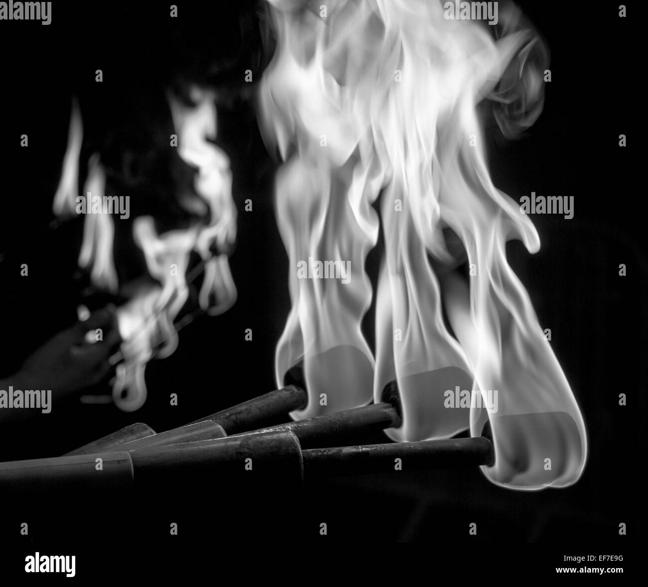 In bianco e nero di fuoco torce di giocoleria Foto stock - Alamy