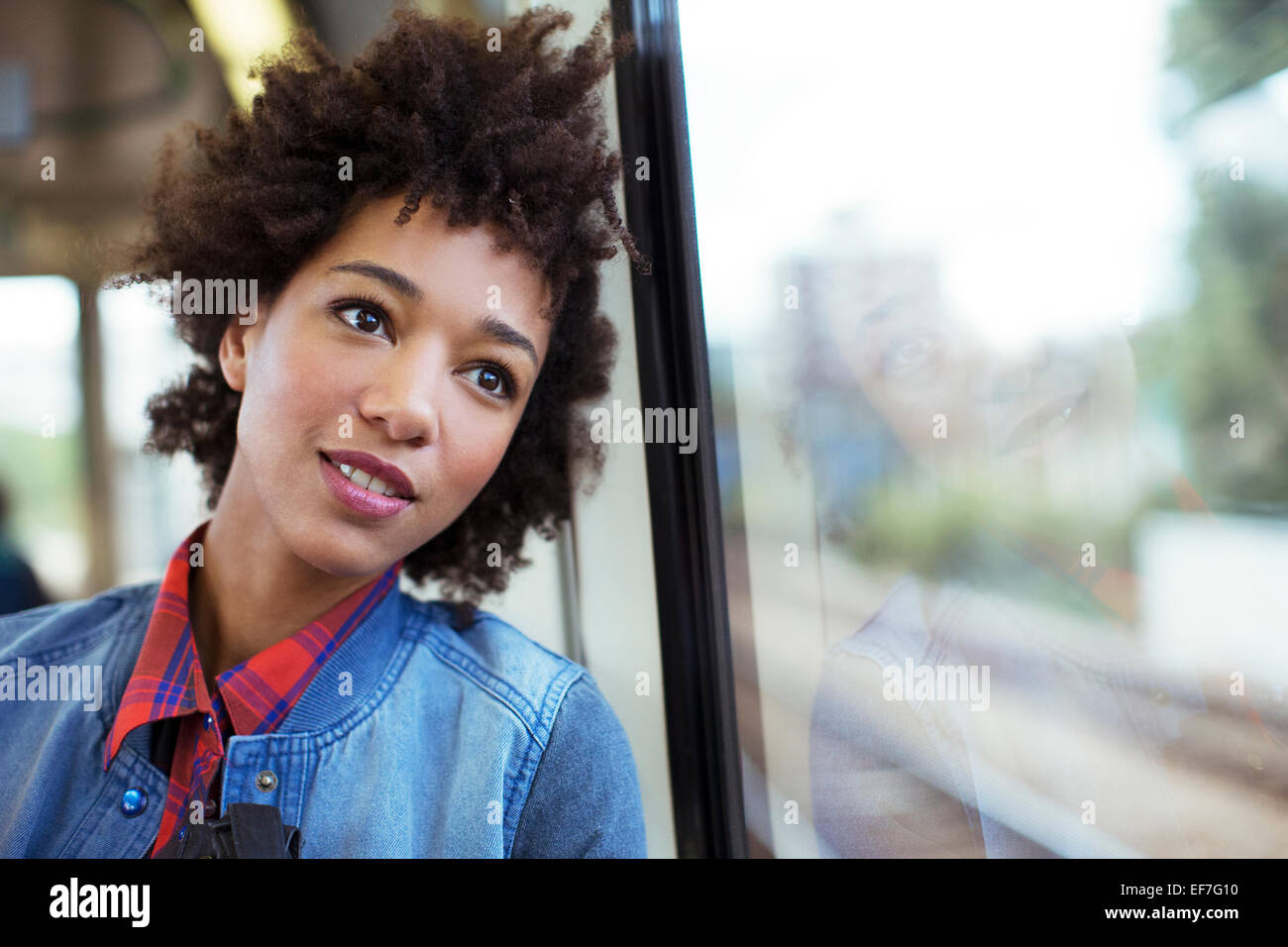 Fantasticando donna a guardare fuori dalla finestra del treno Foto Stock