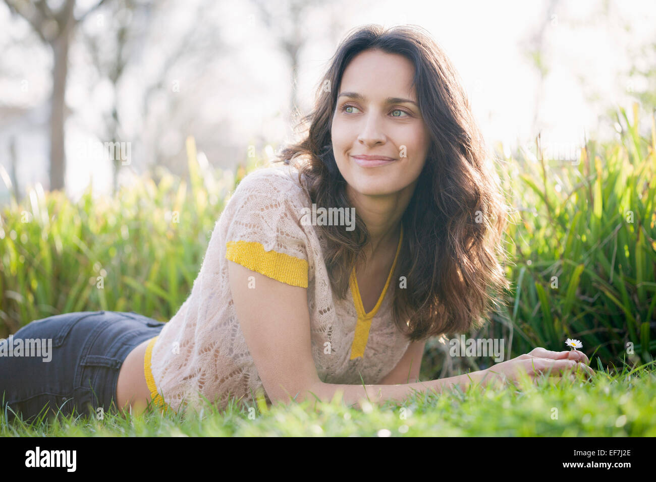 Felice bella donna sdraiati sull'erba Foto Stock