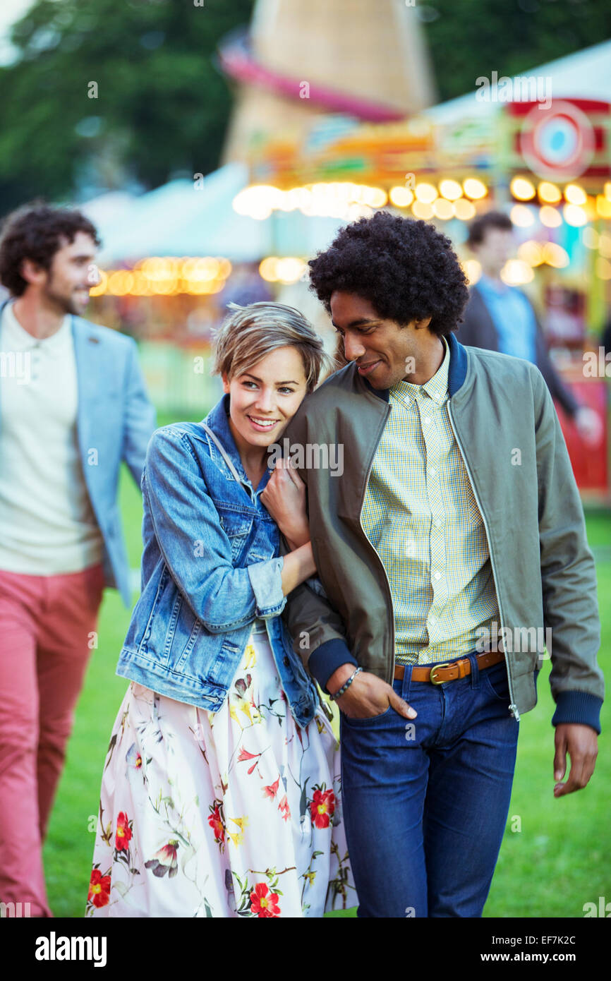 Giovani multirazziale Coppia sorridente nel parco di divertimenti Foto Stock