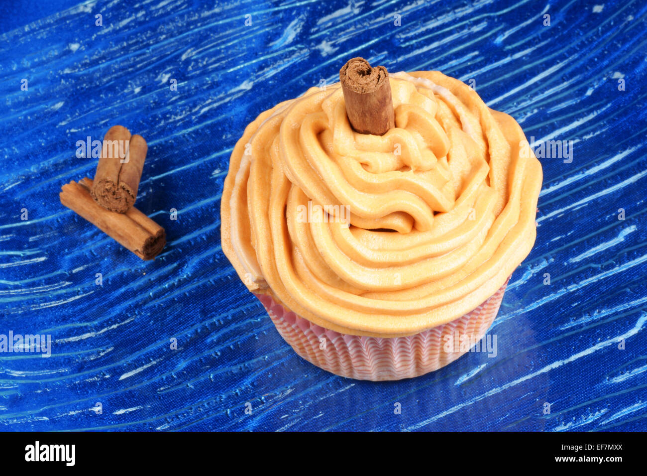 La carota e la cannella cupcake su un piatto di vetro su uno sfondo blu. Foto Stock