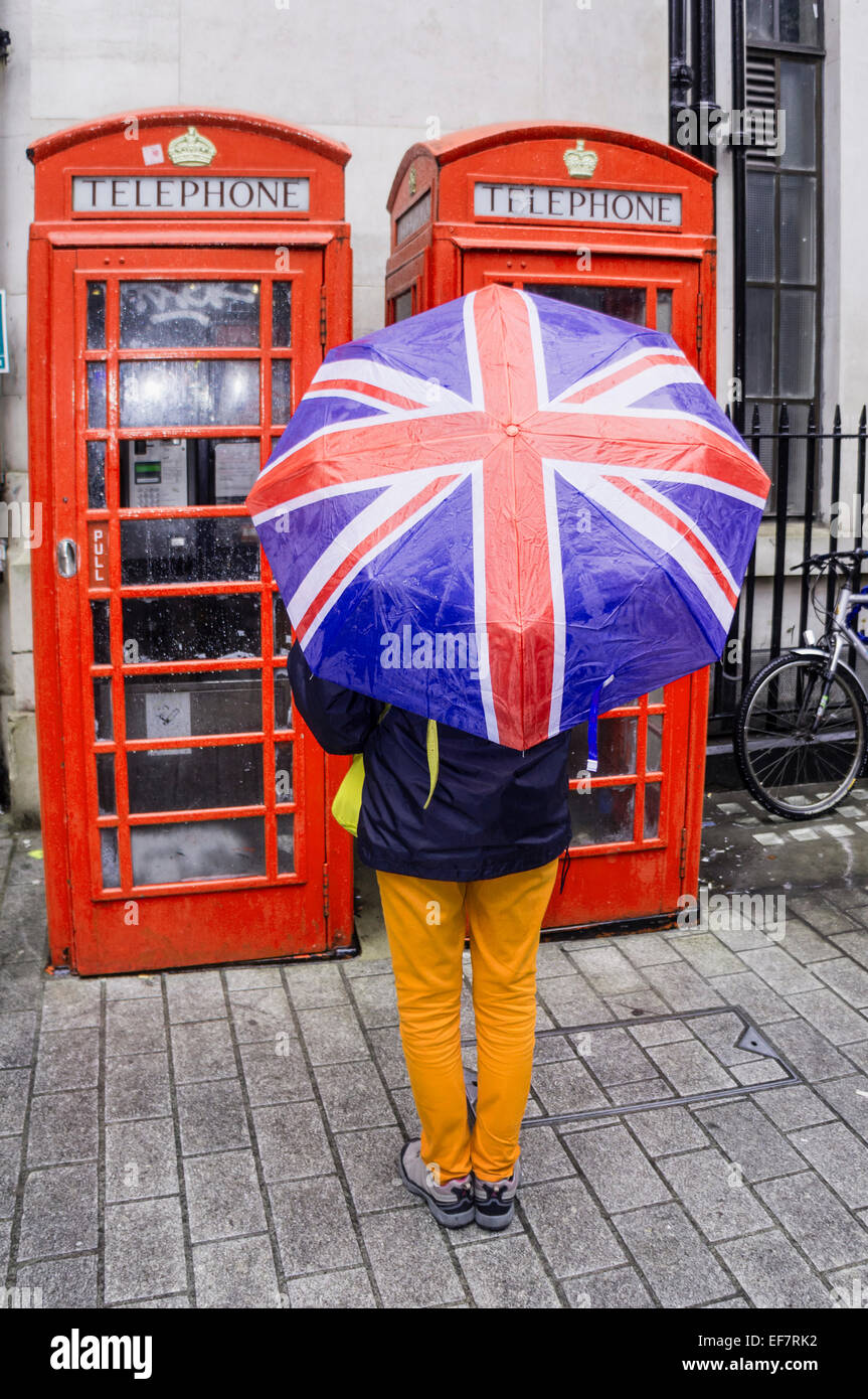 Le donne con ombrellone , Telefono rosso scatola, London, Regno Unito Foto Stock