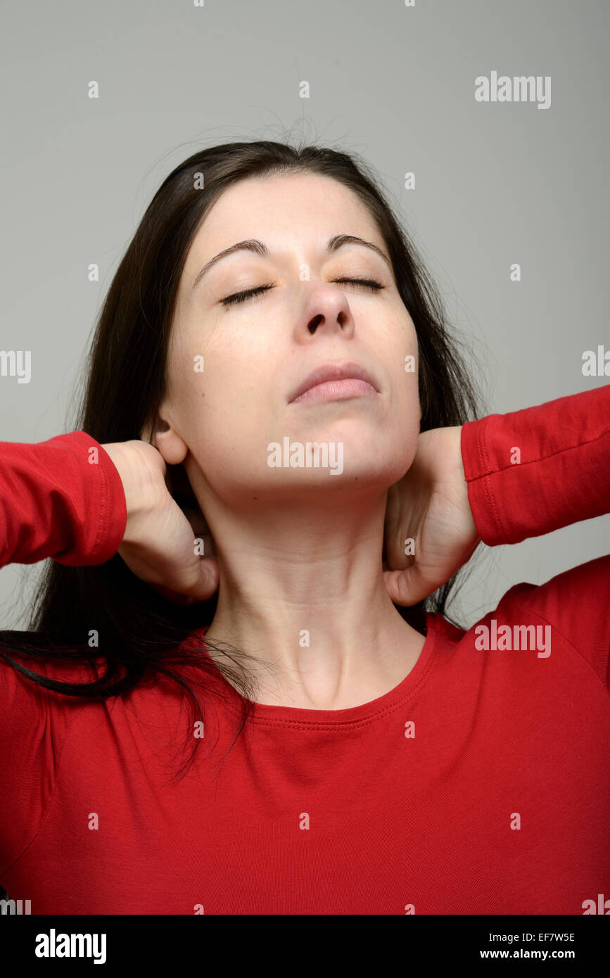 La donna che soffre di dolori al collo Foto Stock