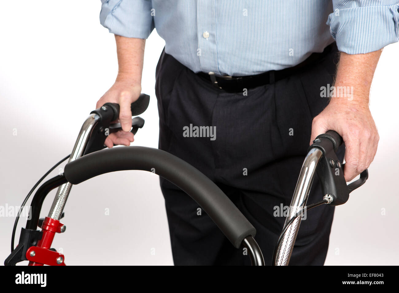 Anziani disabili è uomo utilizzando un deambulatore per evitare di cadere e di dargli stabilità come egli cammina da solo per la vita indipendente. Foto Stock