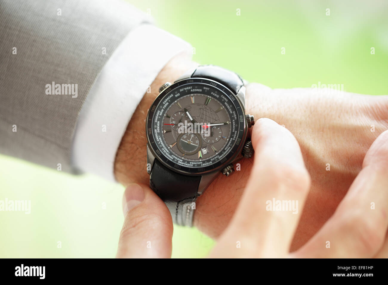 Imprenditore controllando il tempo sul suo orologio da polso nozione di urgenza, scadenza o in ritardo Foto Stock