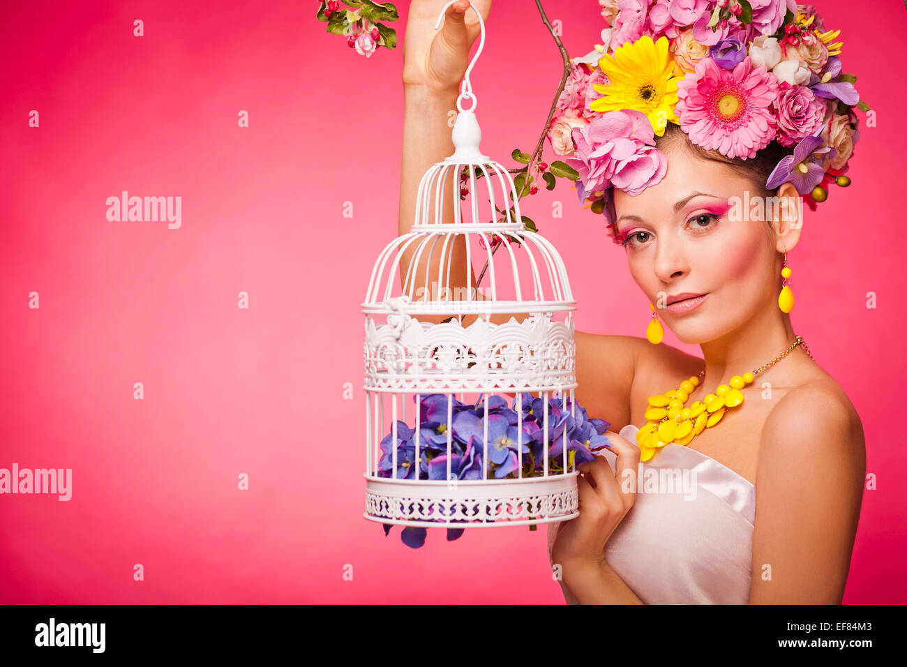 Una sana ragazza con una birdcage e fiori Foto Stock