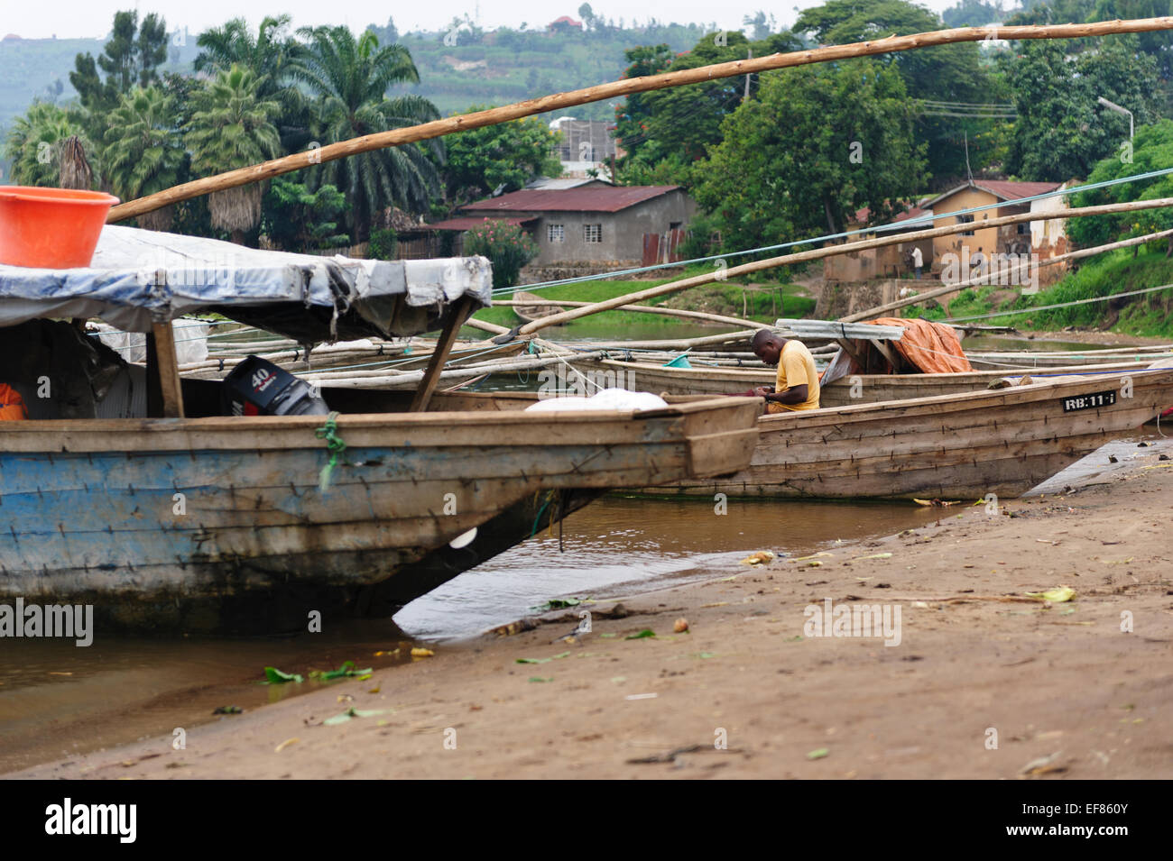 Pescatore riparando le sue reti in una barca da pesca . Il lago Kivu. Ruanda Foto Stock