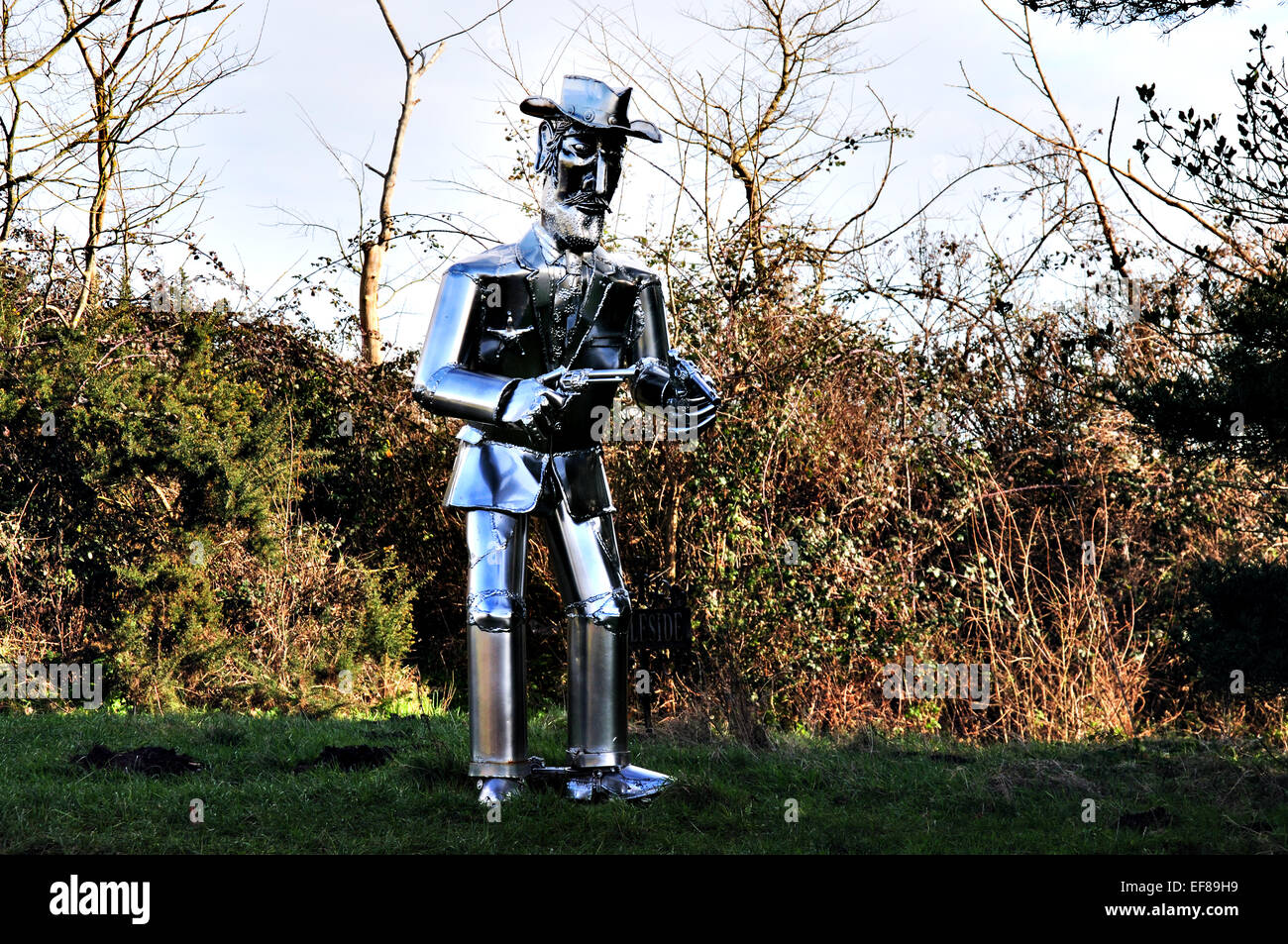 La vita di metallo di dimensioni scultura Cowboy con pistole disegnati sul ciglio della strada in East Anglia, REGNO UNITO Foto Stock