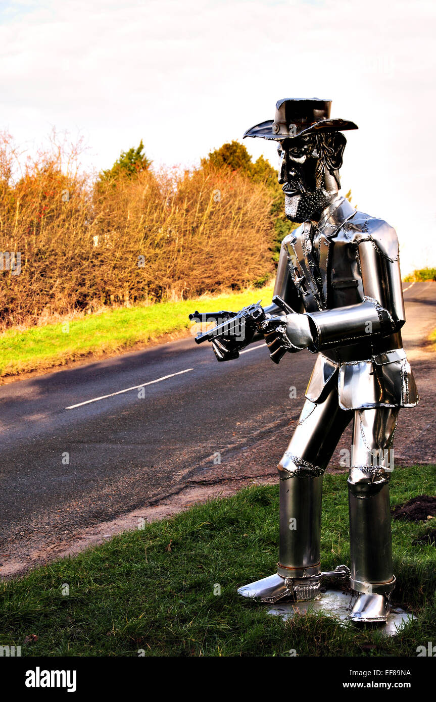 La vita di metallo di dimensioni scultura Cowboy con pistole disegnati sul ciglio della strada in East Anglia, REGNO UNITO Foto Stock