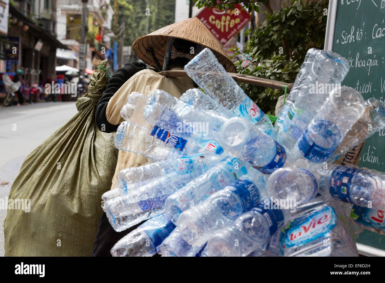 La donna che porta le bottiglie di plastica raccolti per il riciclaggio, Cau può street, Sapa, nel Vietnam del nord Foto Stock