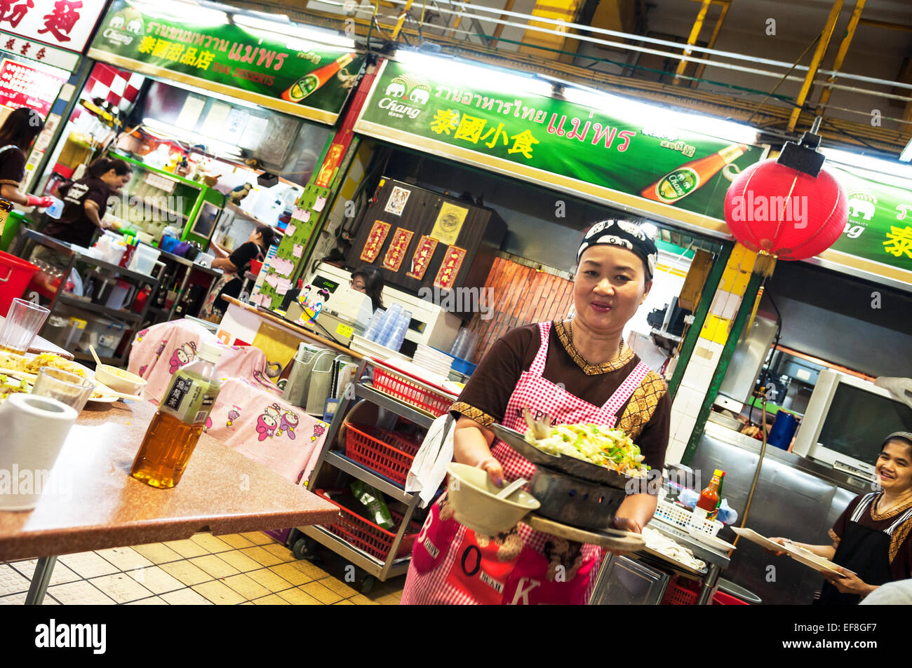 La cameriera che porta i piatti in un ristorante tailandese in Kowloon City il cibo cotto Centre di Hong Kong Foto Stock