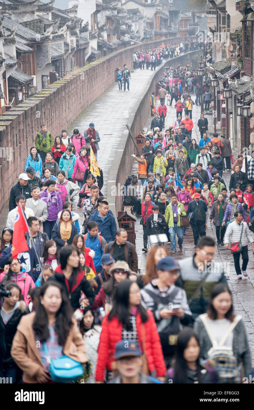 La folla di turisti cinesi a piedi lungo le antiche mura della città di Fenghuang, Cina Foto Stock