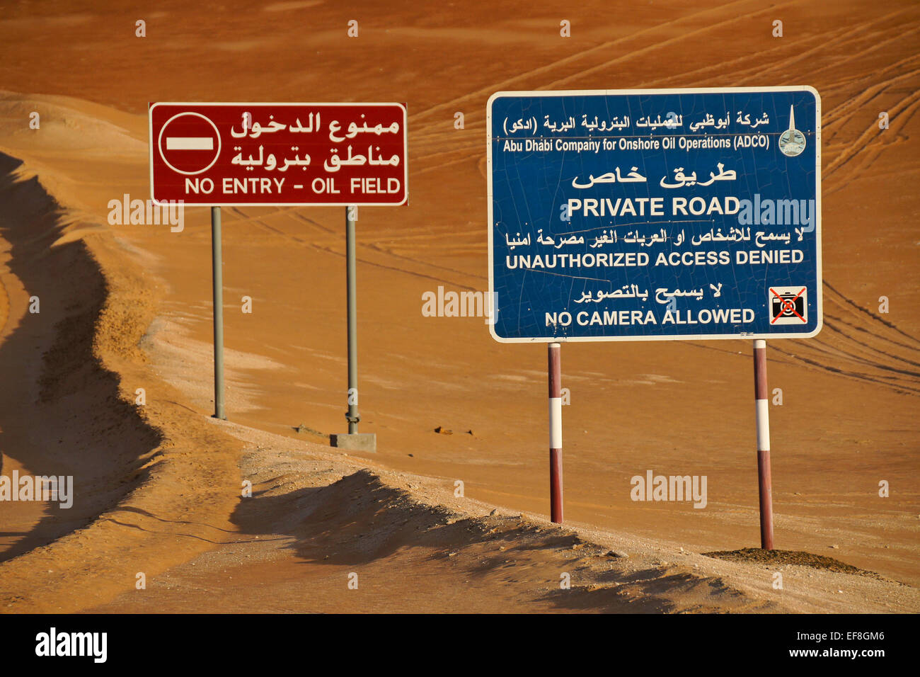 Cartelli di avvertimento accanto alla strada, Liwa dune di sabbia, Abu Dhabi, Emirati Arabi Uniti Foto Stock
