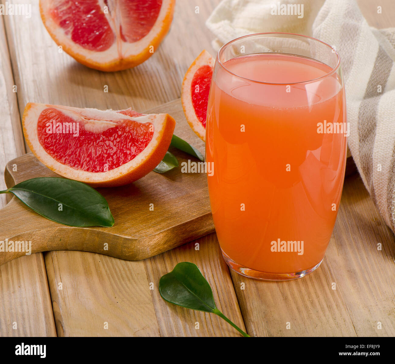 Il succo di pompelmo e pompelmi su un tavolo di legno. Messa a fuoco selettiva Foto Stock