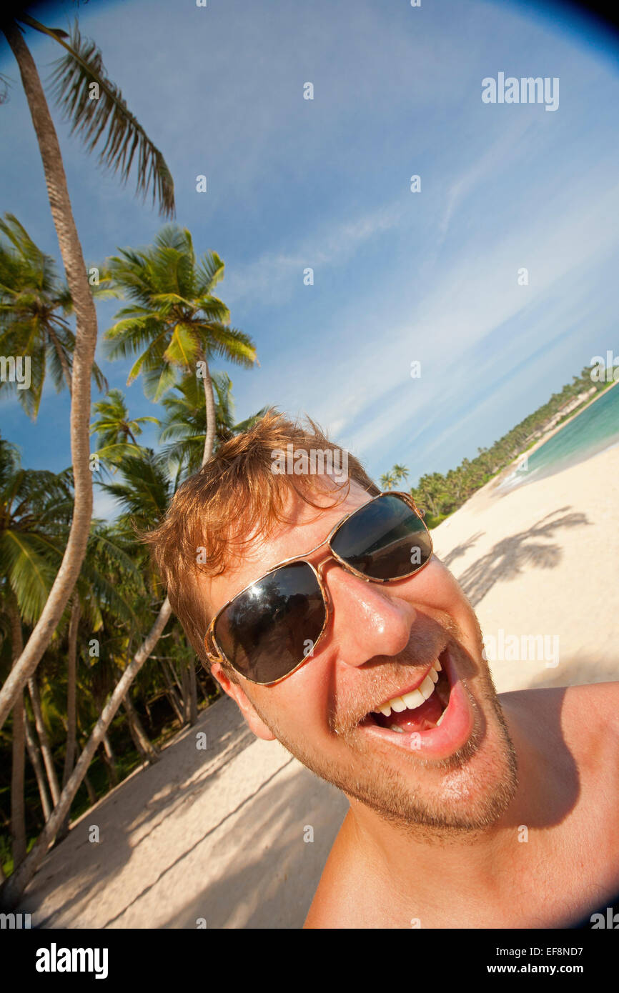 HOLIDAY MAKER sulla spiaggia tropicale con palme Foto Stock