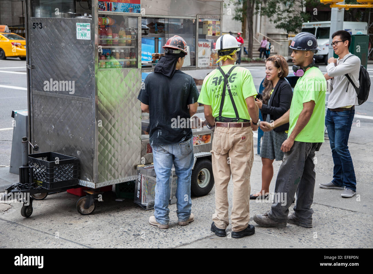 Lavoratori permanente al food cart durante la pausa pranzo a Manhattan, New York City Foto Stock