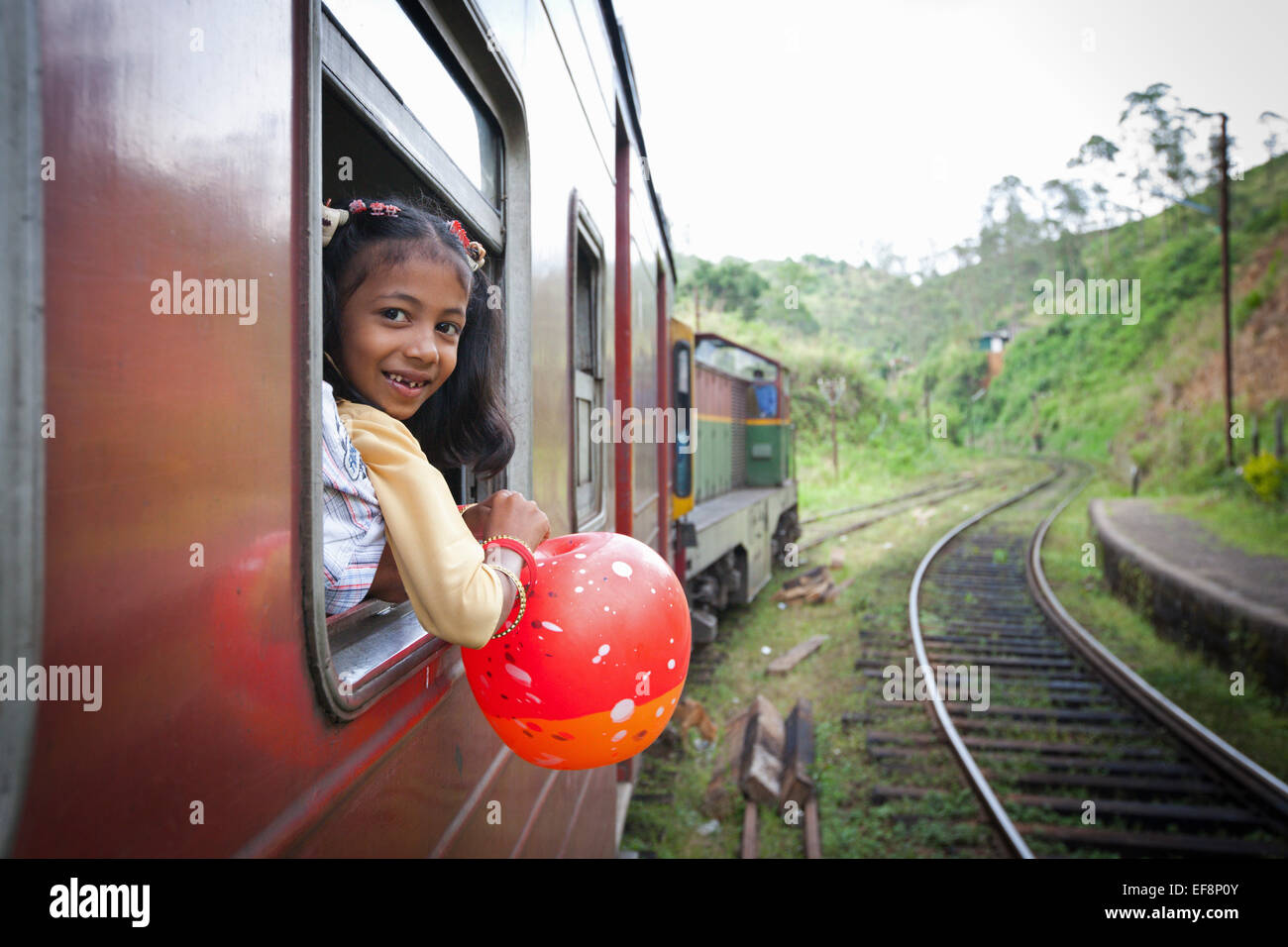 Ragazza appoggiata al di fuori della finestra del treno mentre si viaggia in prossimità HAPUTALE Foto Stock