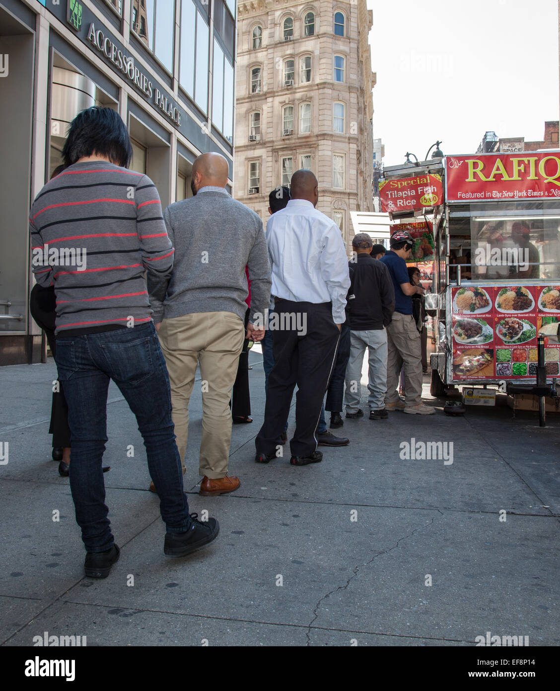 I cittadini di New York in piedi in linea al food cart durante la pausa pranzo Foto Stock
