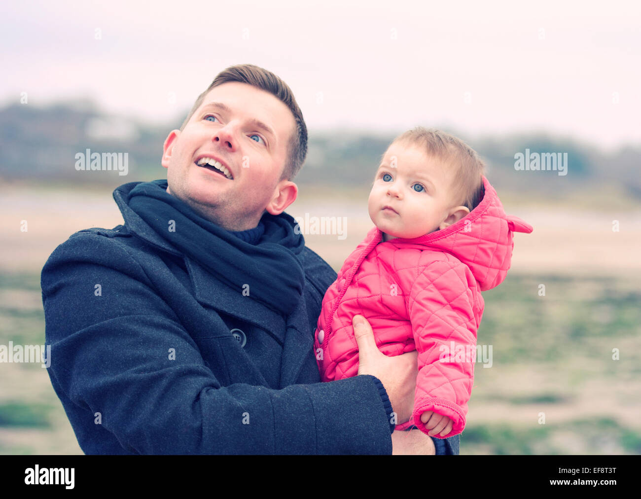 Padre e figlia (6-11 mesi) guardando in alto Foto Stock