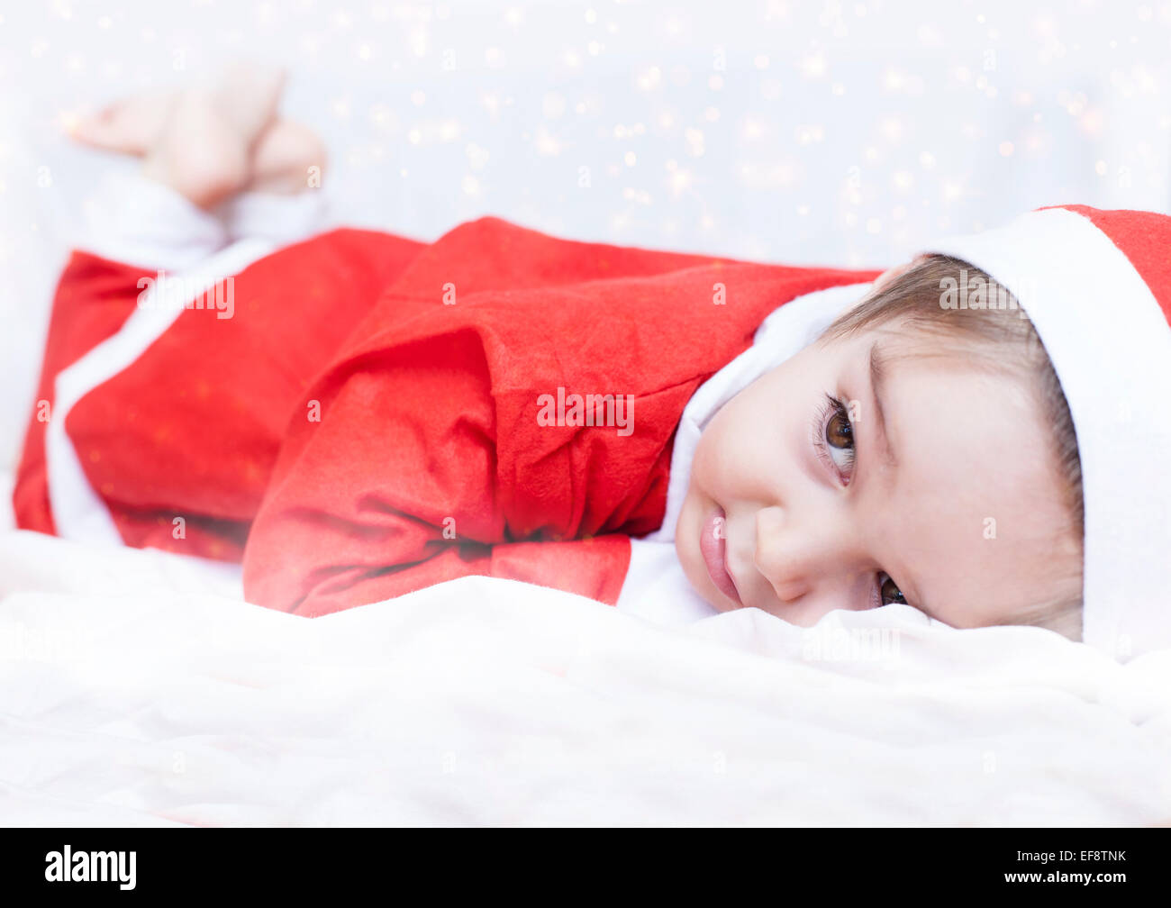 Ragazzo vestiti da Babbo Natale giacente sul letto Foto Stock