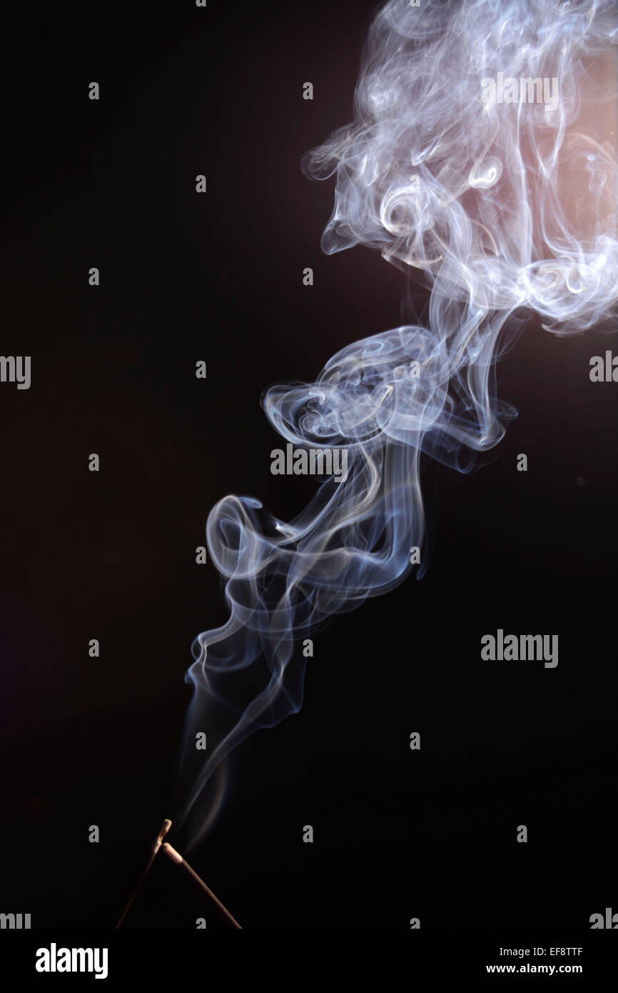 Il Curling fumo da due bastoncini di incenso Foto Stock