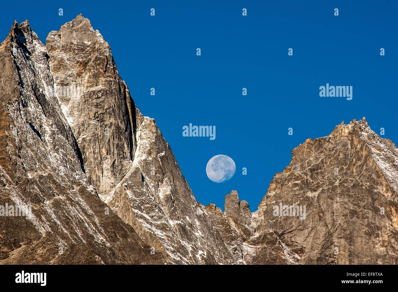 Himalaya, Kumbu, Luna visibile dietro le montagne rocciose nel cielo blu durante il giorno Foto Stock