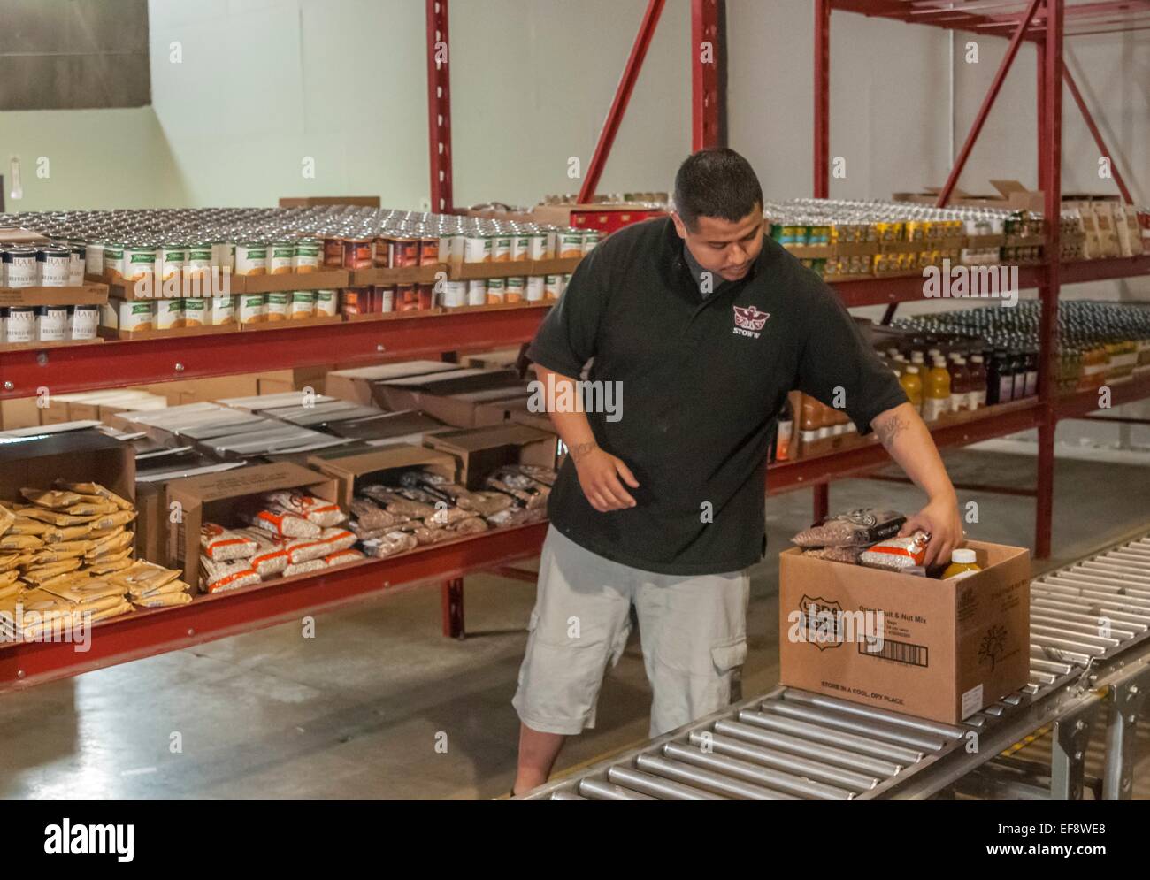 David Gibson un dipendente della distribuzione alimentare programma sulle riserve indiane riempie richieste presso il centro di distribuzione di aiuti alimentari in Sud Lakewood, WA. FDPIR è un programma federale che fornisce cibo nutritivo per famiglie a basso reddito. Foto Stock