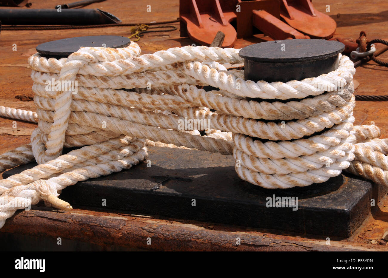 Bianco e spesso le funi utilizzate per legare giù nave industriale Foto Stock