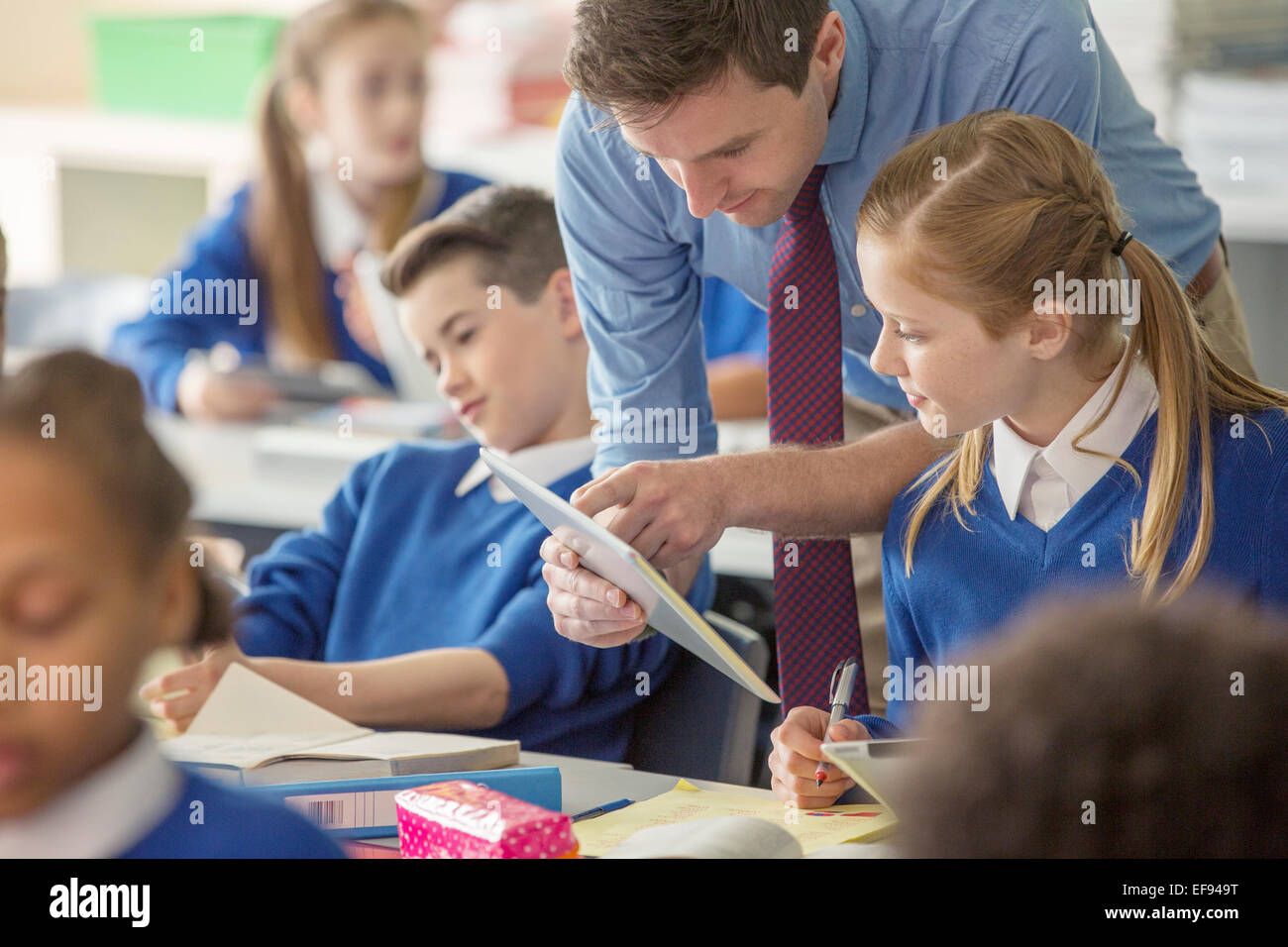 Insegnante con i suoi allievi in aula utilizzando tablet pc Foto Stock