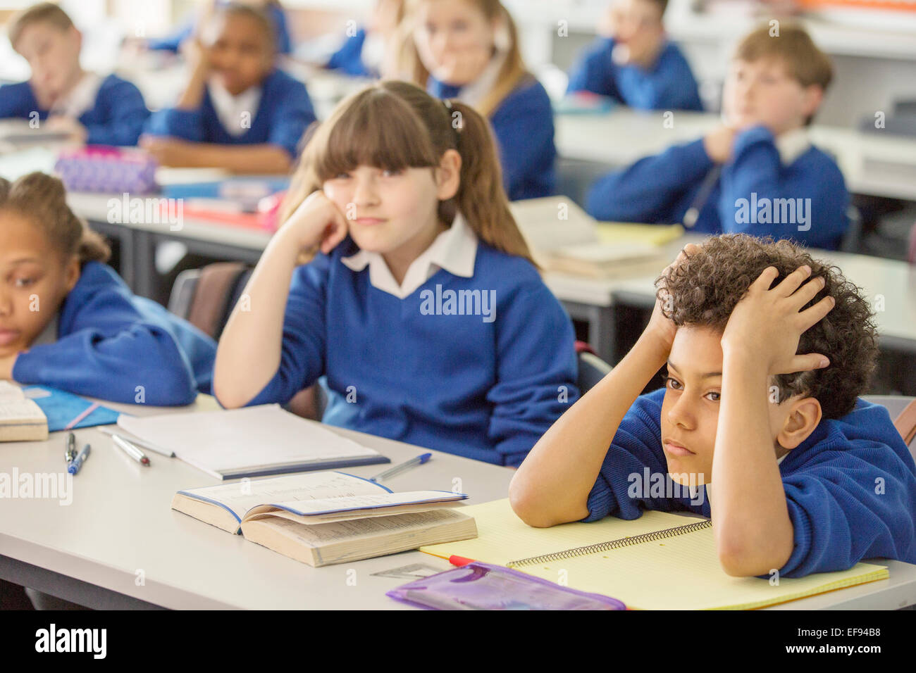 Scuola elementare i bambini annoiati in aula Foto Stock