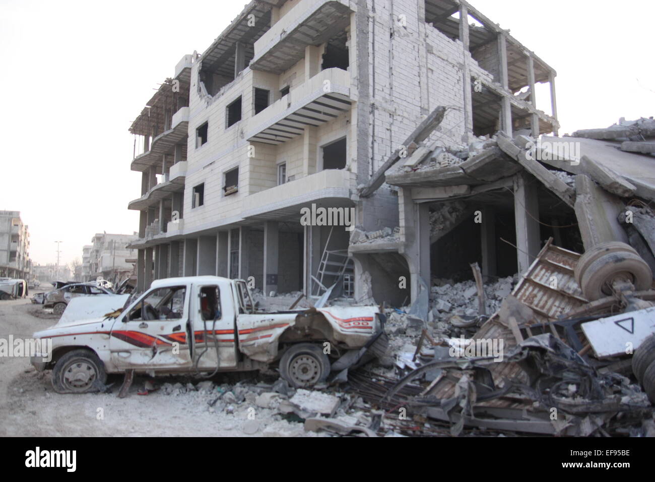 Distrutte auto, case e macerie dominano la deserte le strade nella città di Kobane, Siria, 28 gennaio 2015. Combattenti curdi sono riusciti a spingere indietro le forze del cosiddetto è stato islamico, dalla città di Kobane. Razzi e azioni di combattimento, tuttavia, hanno ucciso molti civili e sinistra Kobane completamente devastata. Foto: Jan Kuhlmann/dpa Foto Stock