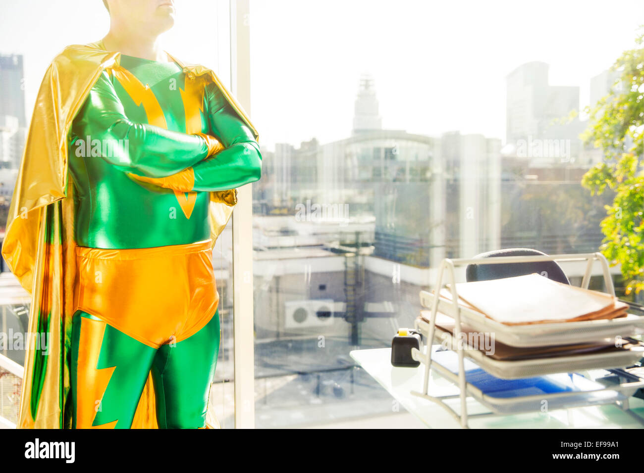 Il supereroe in piedi vicino alla scrivania in ufficio Foto Stock