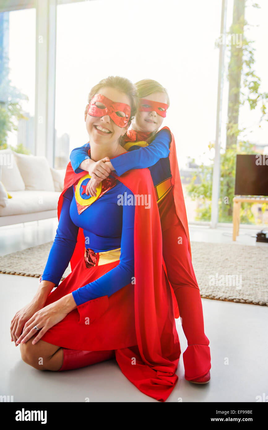 Il supereroe che la madre e il figlio sorridente in salotto Foto Stock