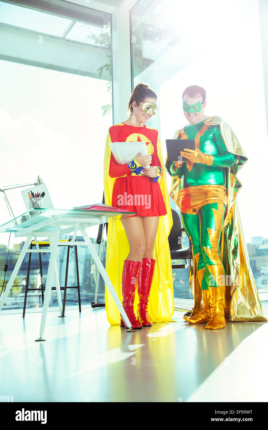 Supereroi lavora con tavoletta digitale in ufficio Foto Stock