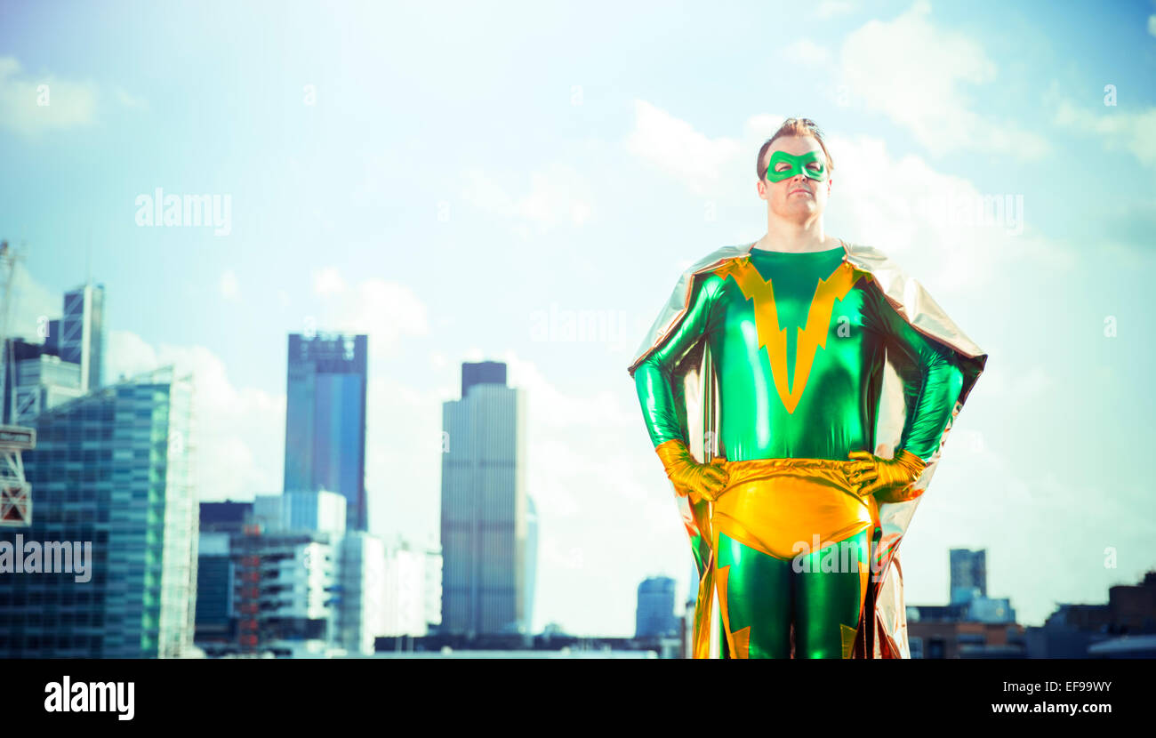 Il supereroe in piedi vicino dello skyline della città Foto Stock