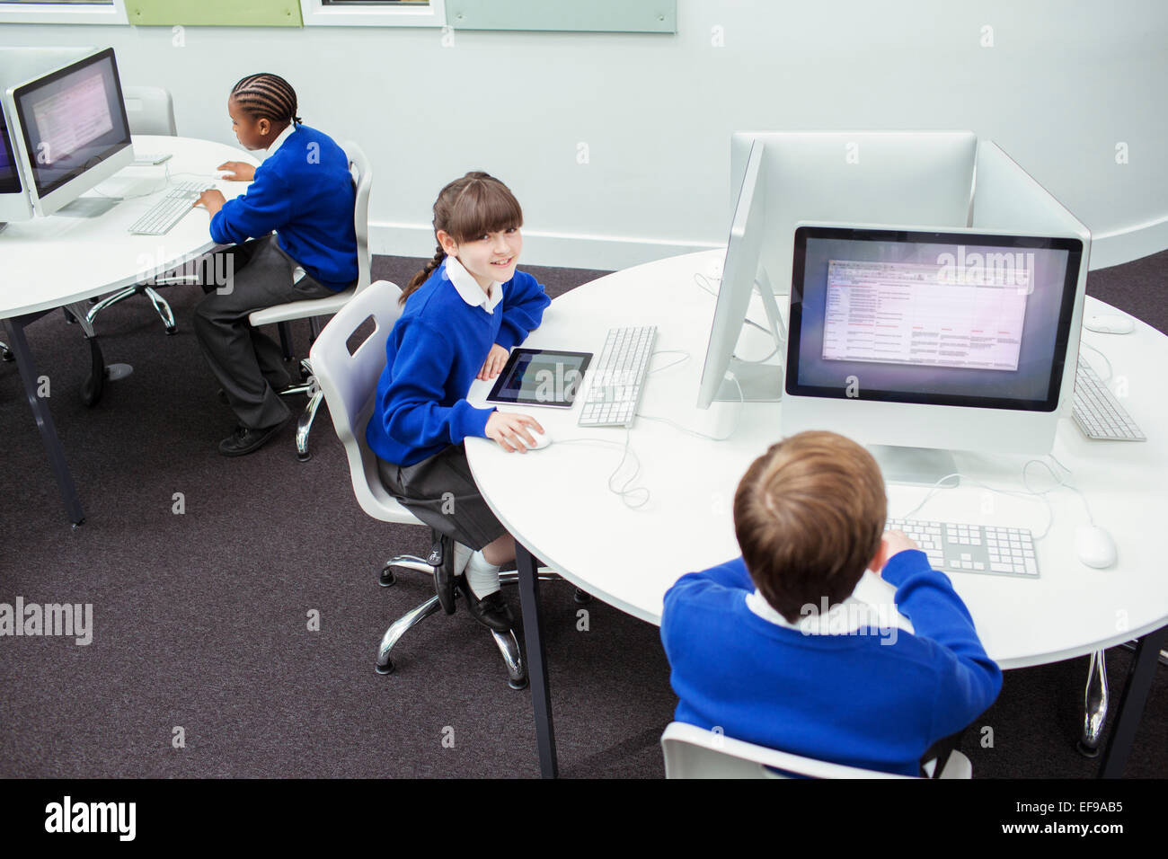 I bambini della scuola elementare a lavorare con i computer Foto Stock