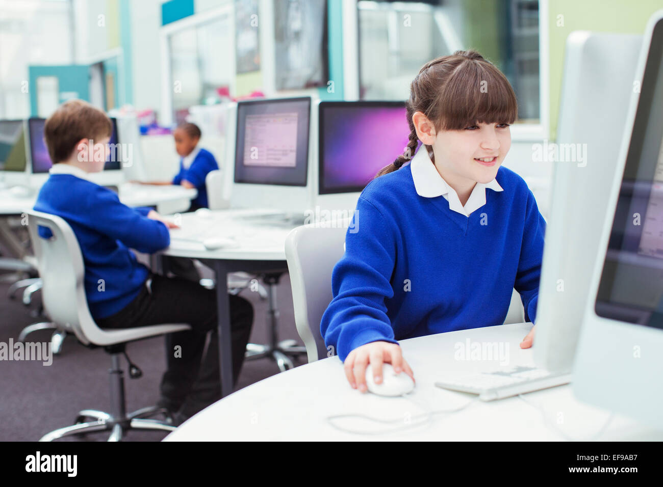 I bambini della scuola elementare a lavorare con i computer durante la lezione Foto Stock