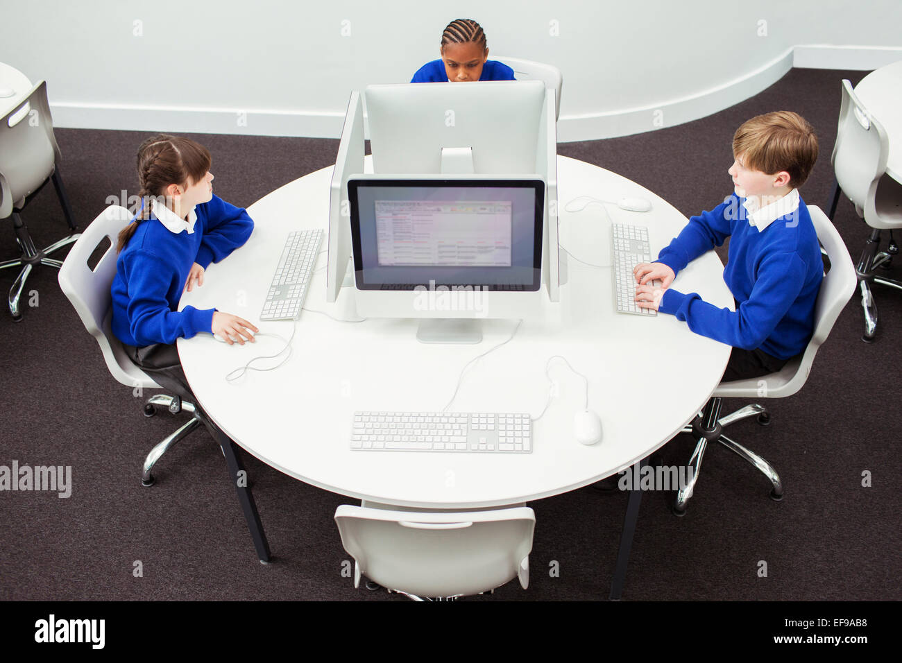 I bambini della scuola elementare a lavorare con i computer durante la lezione Foto Stock