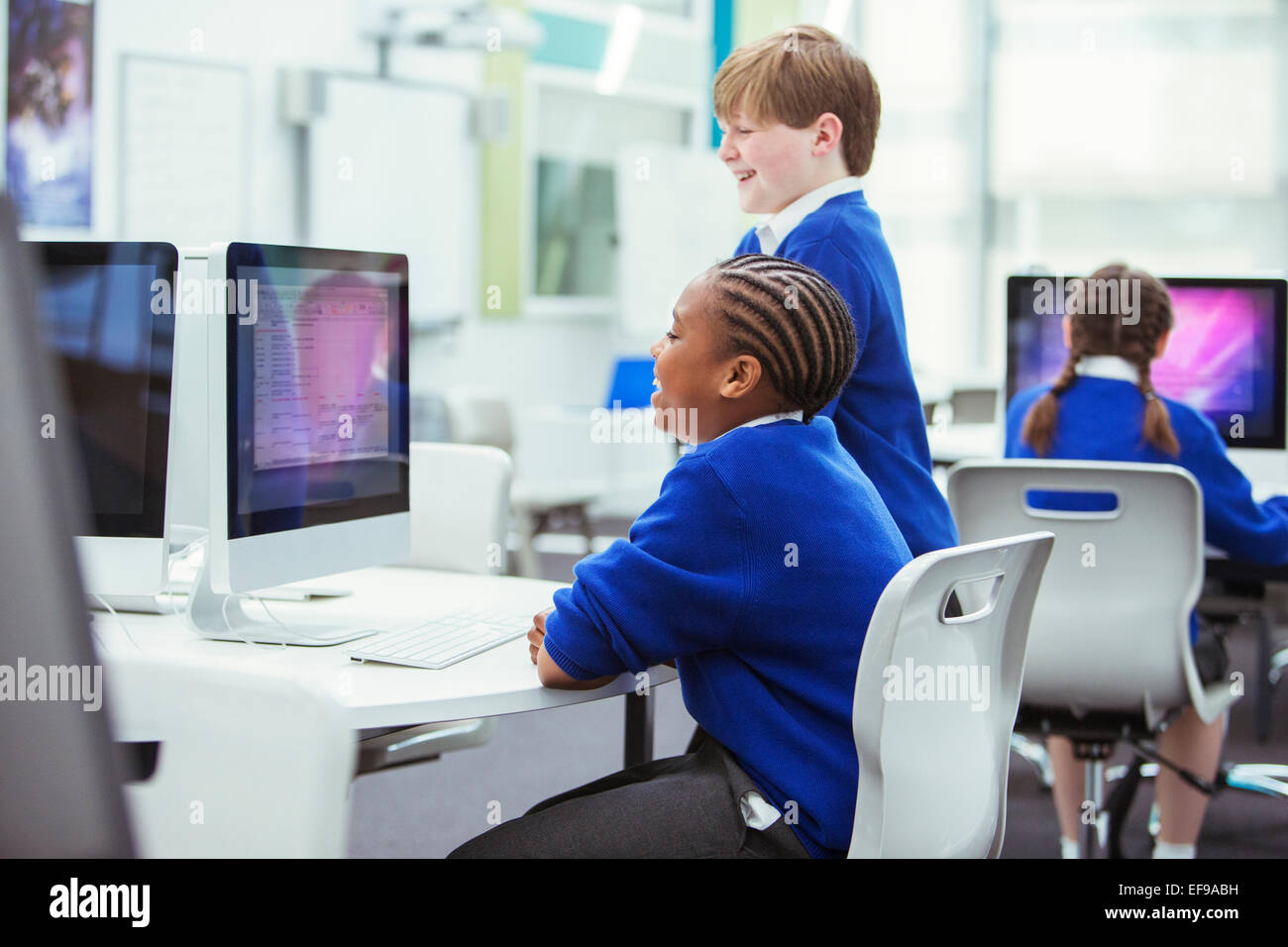 Scuola elementare i bambini che lavorano con i computer Foto Stock