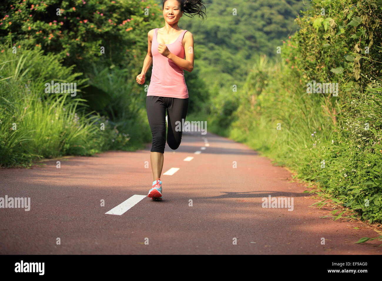 Giovane donna fitness runner in esecuzione sul sentiero forestale Foto Stock