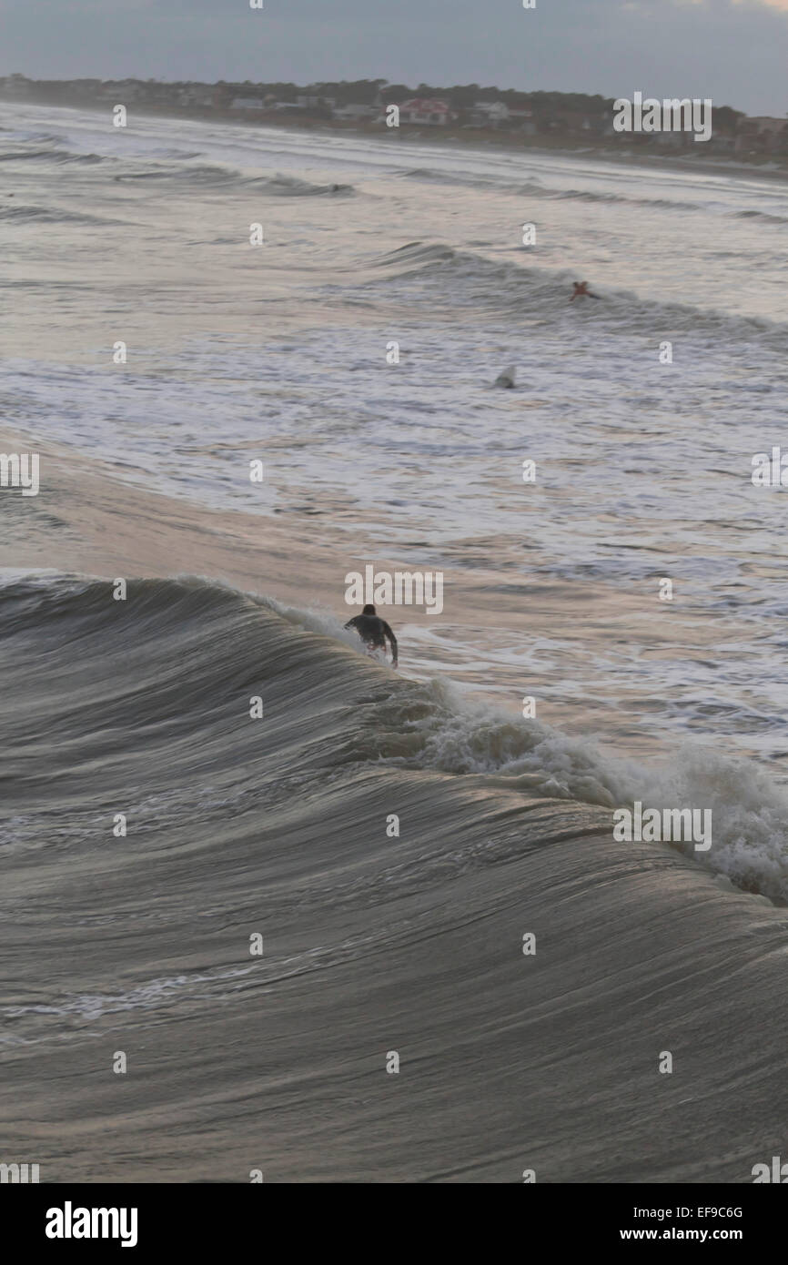 Visto dal di sopra, un surfista cavalca un potente oceano onda dall uragano Sandy vicino al tramonto Foto Stock
