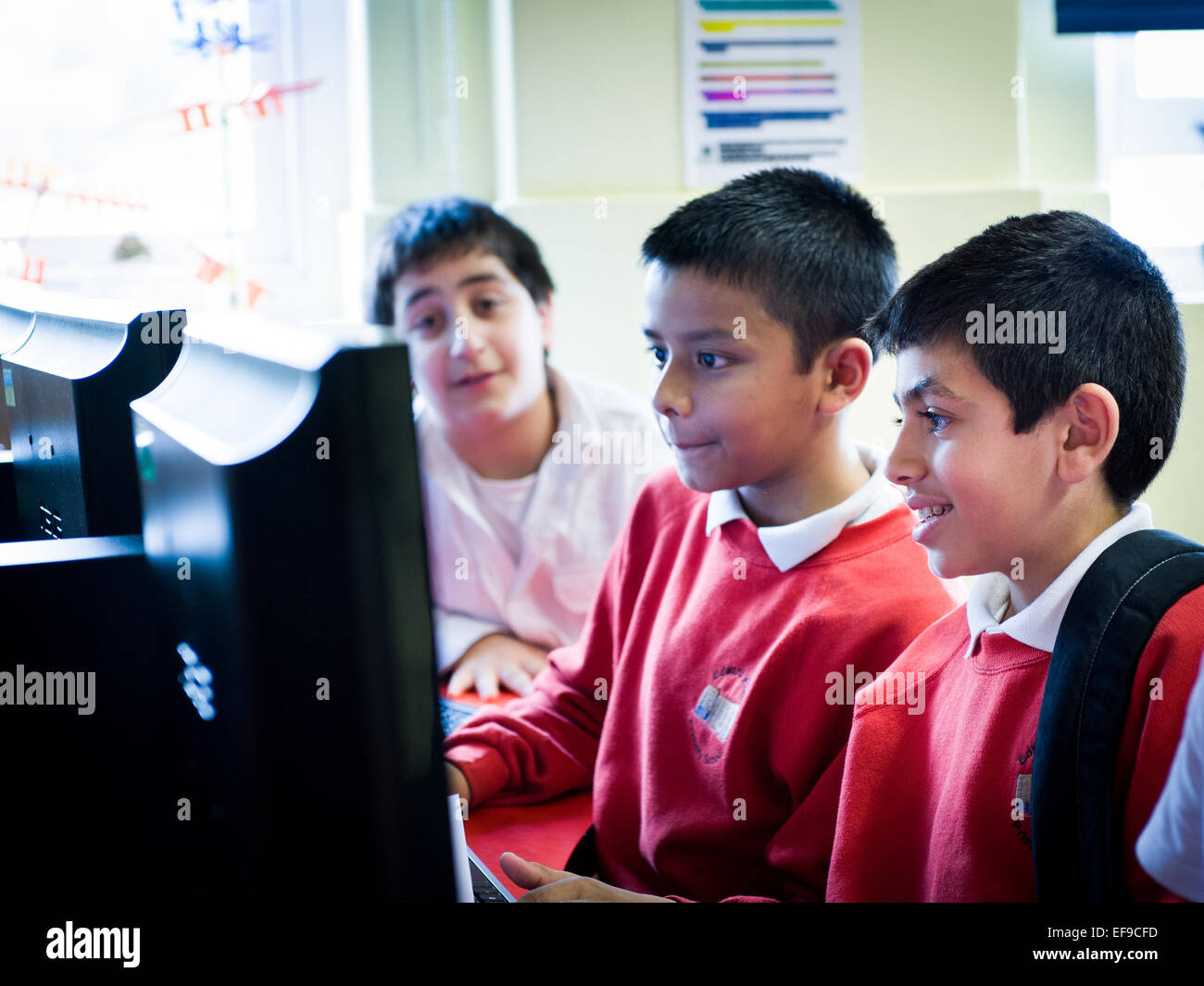 I bambini della scuola elementare presso la scuola primaria a Londra imparare a codice e fare programmazione su computer Foto Stock