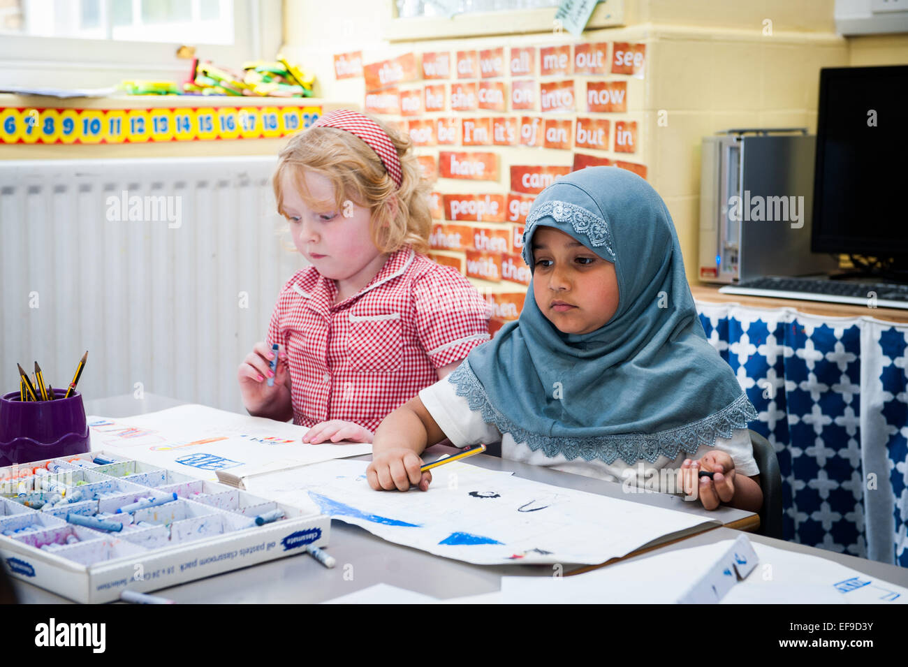 I bambini della scuola elementare di disegno e pittura nella scuola primaria classe,UK Foto Stock