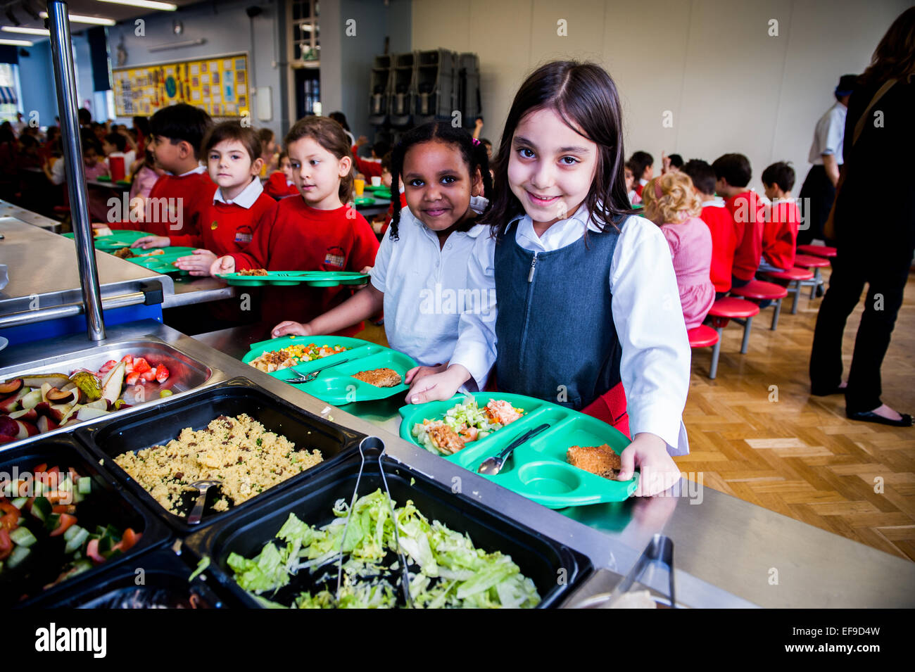 Ora di pranzo presso la UK State Primary School i bambini ricevono cene scolastiche presso la Inner City London Primary School Foto Stock
