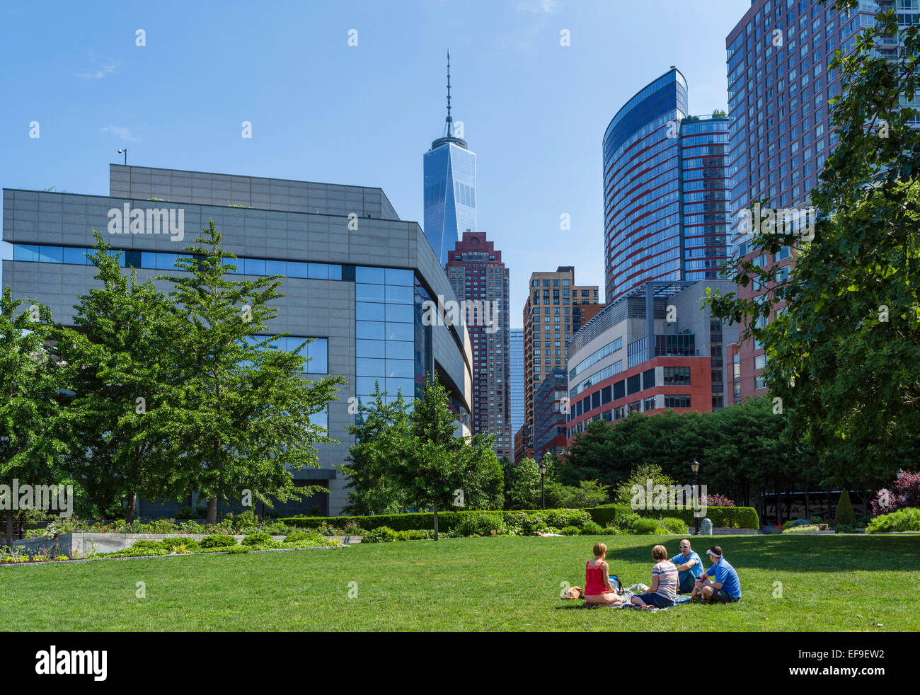 Gruppo di amici seduti sul prato di Robert F Wagner Park, Battery Park City, la parte inferiore di Manhattan, New York City, NY, STATI UNITI D'AMERICA Foto Stock