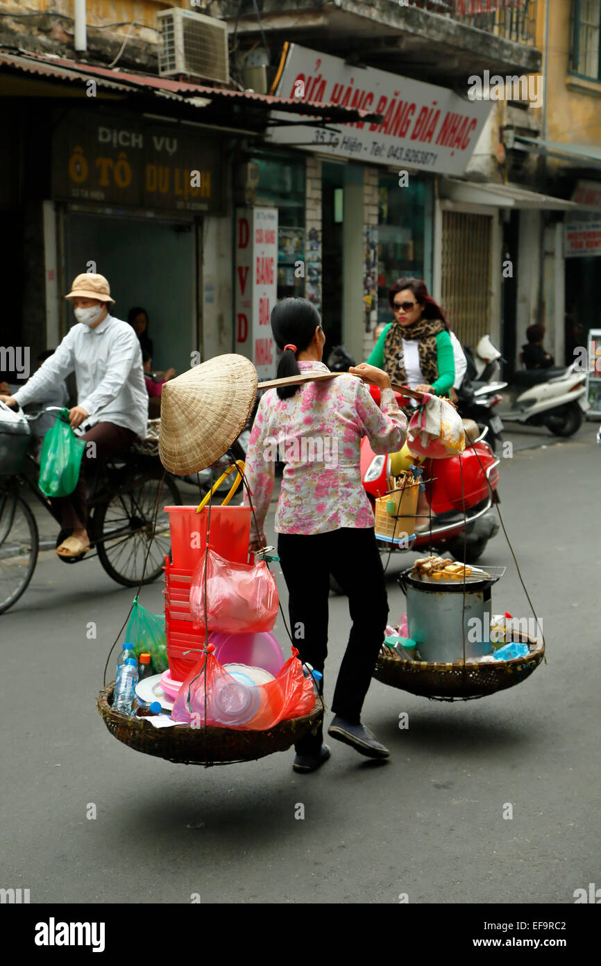 La donna che porta un doppio cestello, Quartiere Vecchio (aka il 36 strade), Hanoi, Vietnam Foto Stock