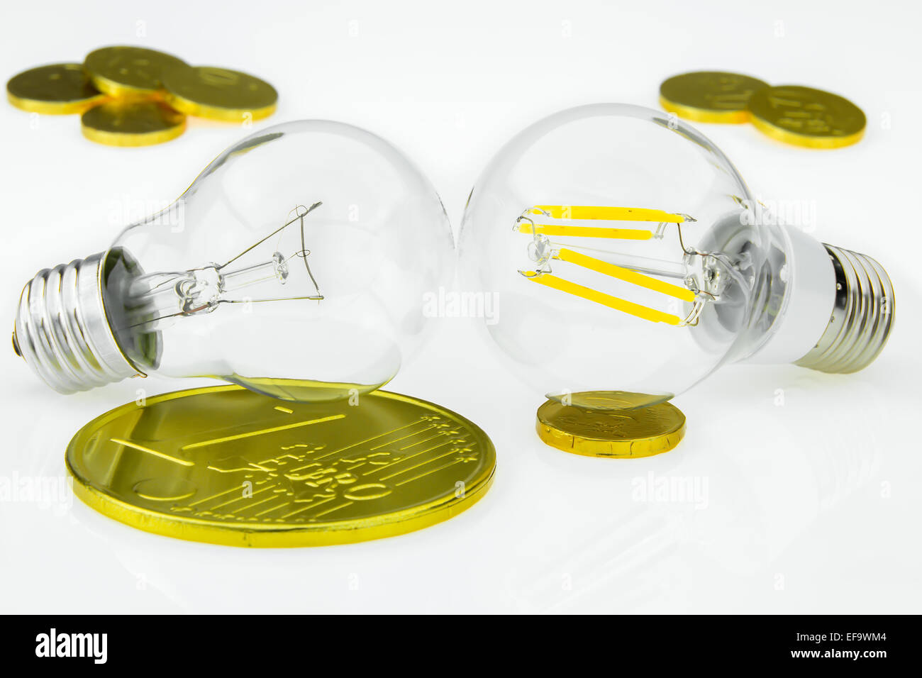 Eco E27 LED e classiche lampadine al tungsteno con simbolico delle monete di cioccolato Foto Stock